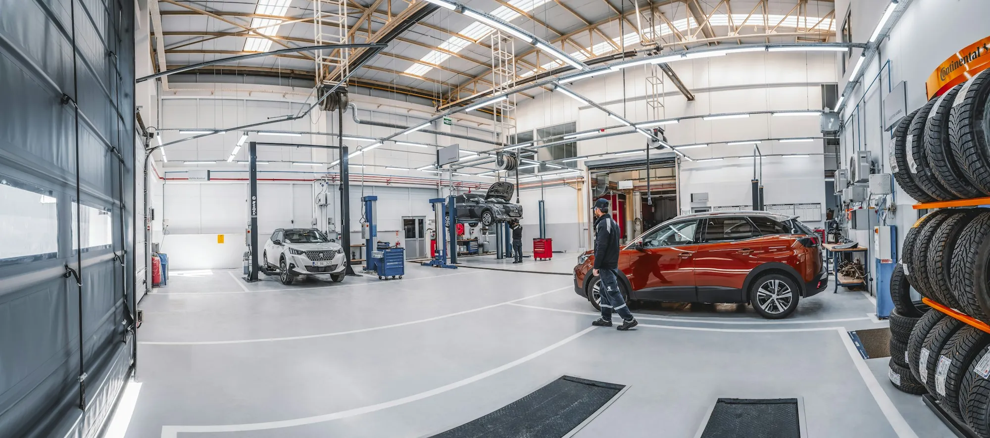 Bright, spacious repair shop with an SUV parked in a bay